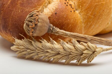 Dried cereal ear and poppy stem with rustic bread concept.の写真素材