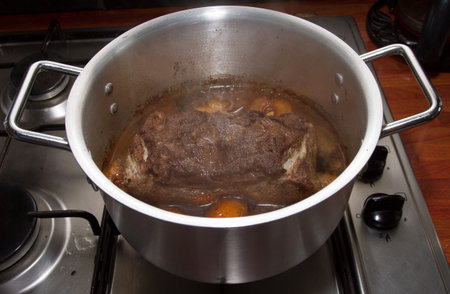 Asian spiced pork with plums simmering in silver cooking pot.の写真素材