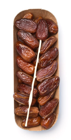 Cardboard tray of date fruits with skewer on white background.の写真素材