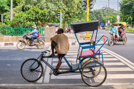 New Delhi / India - September 19, 2019: Driver sitting on his bicycle rickshaw in the streets of New...