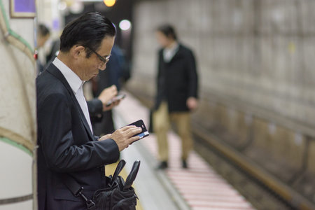 Tokyo / Japan - April 19, 2018: Businessman waiting for a subway in Tokyo