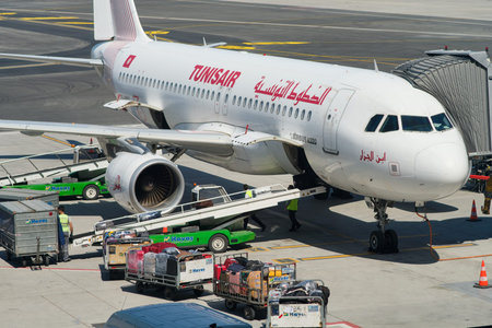 Istanbul / Turkey - September 14, 2019: Airport workers loading the luggage bags into a Tunisair...
