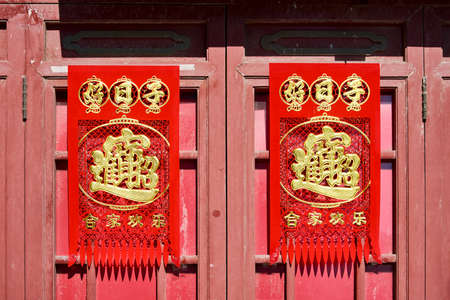 Beijing / China - February 14, 2016: Old door in traditional Beijing hutong alley, decorated with Chinese characters during Chinese New Year celebrationsのeditorial素材