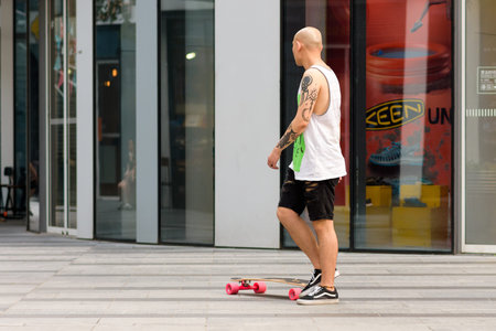 Beijing / China - August 21, 2016: Skater with a skateboard in modern Sanlitun area of Chaoyang...