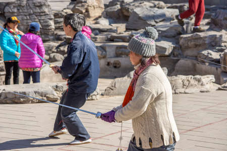 BEIJING / CHINA - March 13, 2016: Chinese people practicing tai chi with a sword in the park, Beijing, Chinaのeditorial素材
