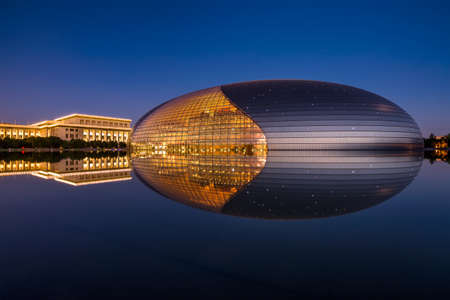 Beijing / China - July 12, 2016: National Centre for the Performing Arts and National Peoples Congress, reflecting in a lake at night in Beijing, Chinaのeditorial素材