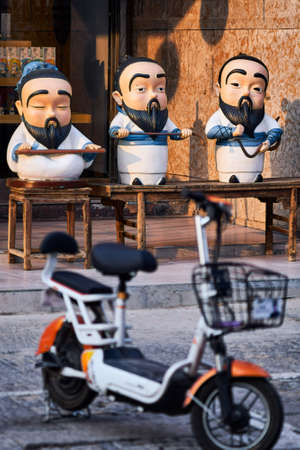 Qufu / China - October 13, 2018: Street scene, cartoon-like statues of Confucius in Qufu, Shandong province, China. Qufu is famous as the birthplace of ancient Chinese philosopher Confuciusのeditorial素材