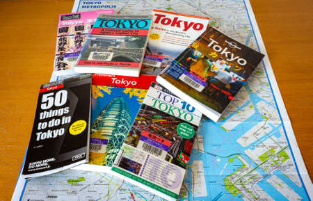 Tokyo / Japan - October 15, 2017: Various Tokyo travel guides with Tokyo City Map spread on the table. Planning journey to Tokyo.のeditorial素材