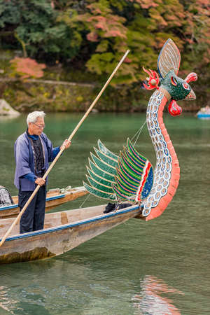 Kyoto / Japan - November 12, 2017: Old man rowing on Ruytou-sen Dragon Head boat during festival on Katsura river in Kyoto, Japan.のeditorial素材