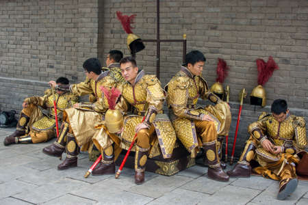 Xian / China - August 4th 2015: Group of men dressed as ancient Chinese Tang dynasty warriors in the Old walled city of Xian Chinaのeditorial素材