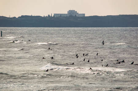 Okinawa / Japan - February 27, 2018: Large group of surfers riding the waves of East China Sea, Okinawa island of Japanのeditorial素材