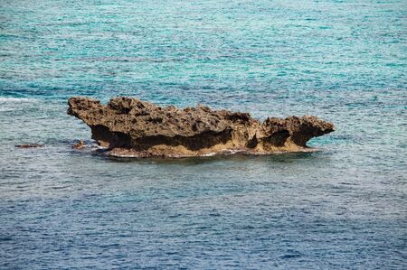 Blue sea and volcanic rock formations on the coast of Okinawa island in Japanの写真素材
