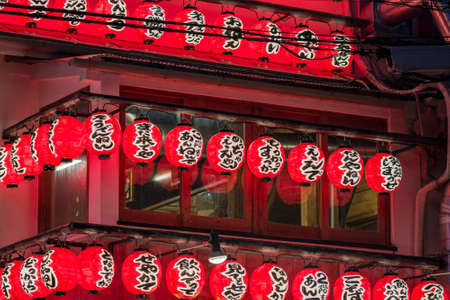 Osaka / Japan - March 19, 2018: Bright red lanterns advertising an Izakaya restaurant and bar in Dotonbori area in central Osaka. An izakaya is a type of informal Japanese pub for after-work drinkingのeditorial素材
