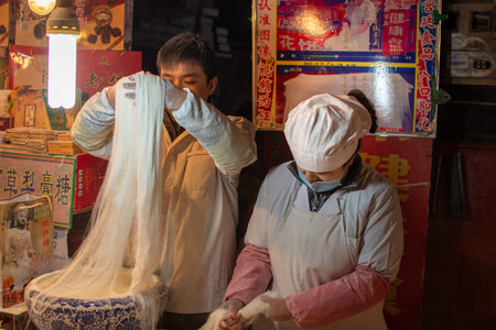 Luoyang, Henan Province / China - January 3, 2016: Cooks preparing flour noodles at a street vendor...