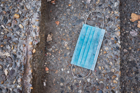 Discarded protective medical face mask against COVID-19 Coronavirus pandemicの写真素材