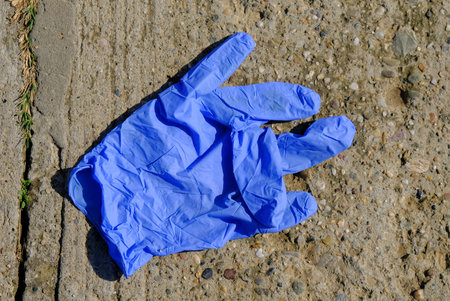 Discarded protective medical glove against COVID-19 Coronavirus pandemic