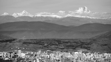 Black and white cityscape view of Tbilisi, the capital of Georgia with snow-capped Caucasus...