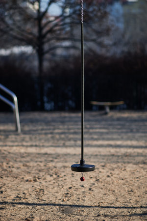 A playground with a seat on a sandy surface.の写真素材