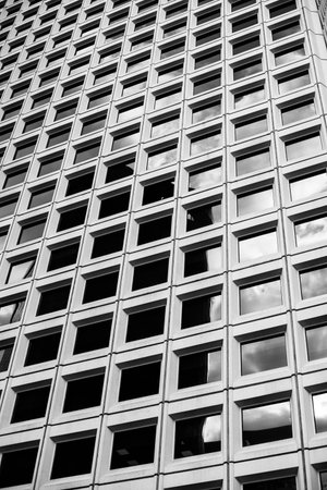 Black and white photo of a modern building facade with square windows.の写真素材