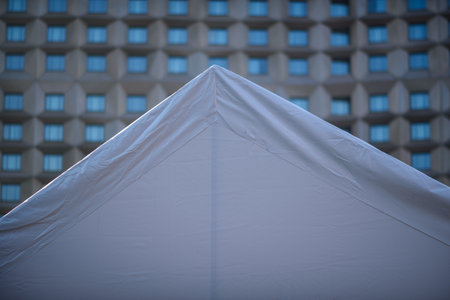 White tent peak against a geometric building facadeの写真素材