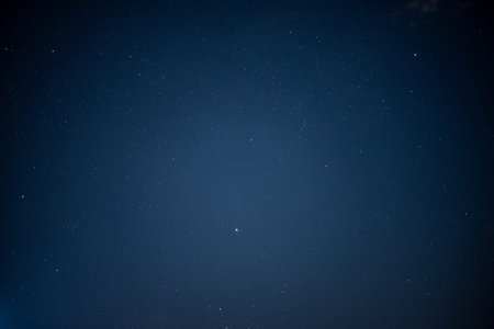 A clear night sky filled with stars, showcasing a deep blue background