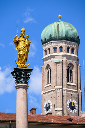 Marian column on Marienplatz square with Frauenkirche Cathedral of Our Lady, Roman Catholic church in the background, two symbols of the city of Munich in Bavaria, Germanyの写真素材
