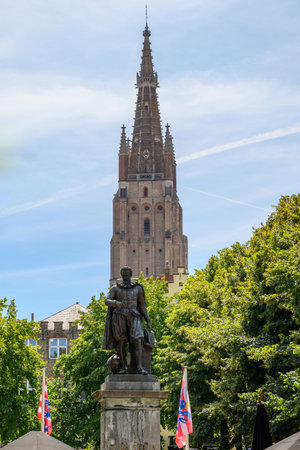 The Statue of mathematician Simon Stevin and Church of Our Lady Roman Catholic gothic church in Bruges, Belgium on 17 July 2025の写真素材