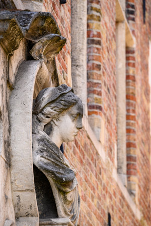 Stone bust of a woman on a brick building facadeの写真素材