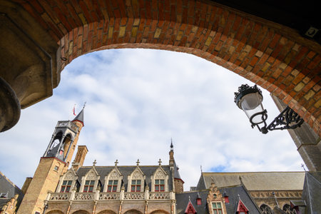 Historic European architecture with arched brick entrance and cloudy sky.の写真素材