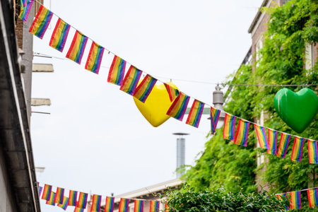 Colorful pride flags with rainbow colors hanging between buildings, symbolizing diversity and inclusivity in Amsterdam, Netherlands on 21 July 2025の写真素材