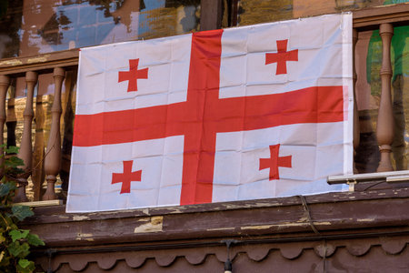 Georgian flag hanging on a wooden balcony.の写真素材