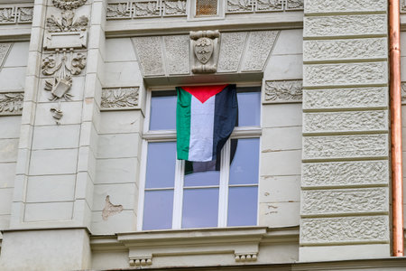 Palestinian flag hanging from a window of an ornate building, showing support for Palestineの写真素材