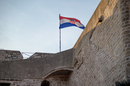 Flag of Croatia atop the medieval walls of the Old Walled City of Dubrovnik, UNESCO world heritage site at the Adriatic Sea in Republic of Croatiaの写真素材