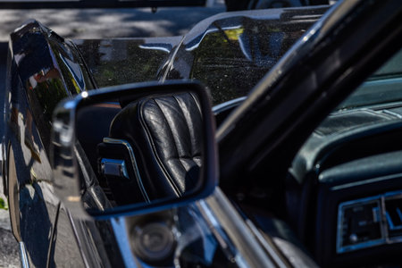 Close-up of a classic old timer car's interior with leather seats and side mirror