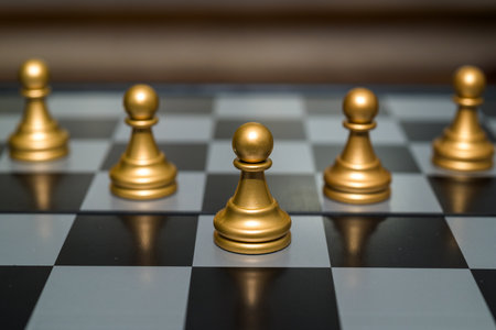 Chessboard with close up of black pawns in arrow formation chess game piecesの写真素材