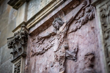 Stone relief of a crucifixion scene on a historic building facade.