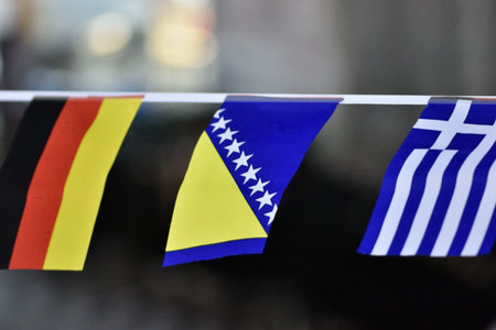 Three small flags hanging on a string: Germany, Bosnia and Herzegovina, Greece.の写真素材