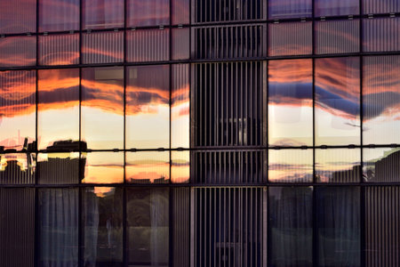 Sunset reflections on a modern glass building facade.の写真素材