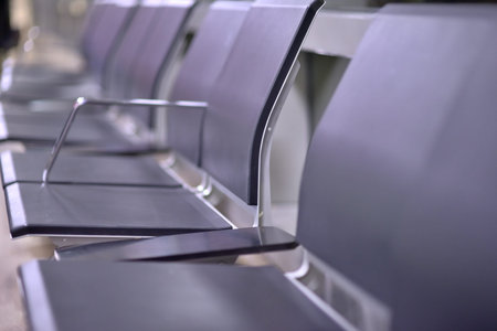 Empty row of modern airport chairs with a blurred background.