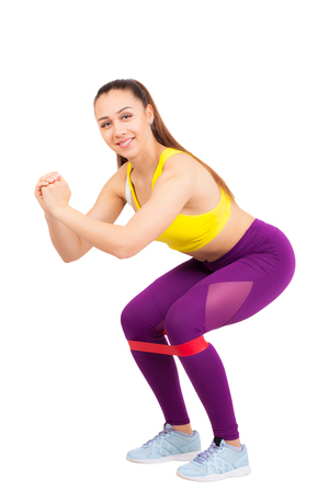 athletic girl with a gym rubber band on her legs. isolated on white backgroundの写真素材