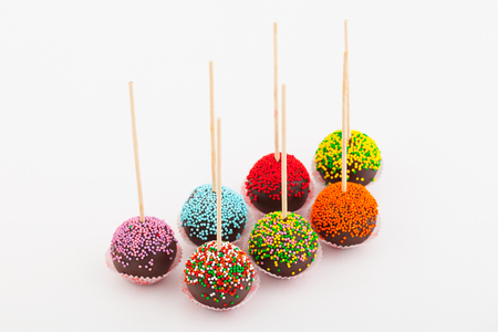 colored cup cake on stick, on white backgroundの写真素材