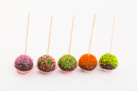 colored cup cake on stick, on white backgroundの写真素材
