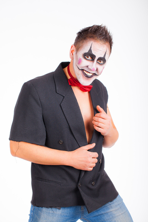 A man in the makeup of an evil clown smiling. The image for halloween. Studio photo on a white backgroundの写真素材