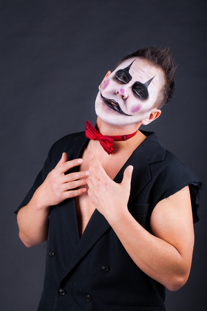 A man in the makeup of an evil clown with closed eyes. Image for Halloween. Studio photo on a black backgroundの写真素材