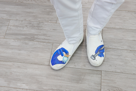 feet of the dentist in shoes with pictures, the subject of dentistry, top view. professional shoesの写真素材