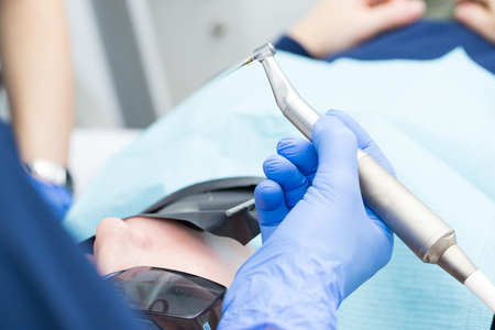 Close-up picture of dental instruments: drill and needle for root canal treatment and pulpitis in hand at the dentist in a blue gloveの写真素材