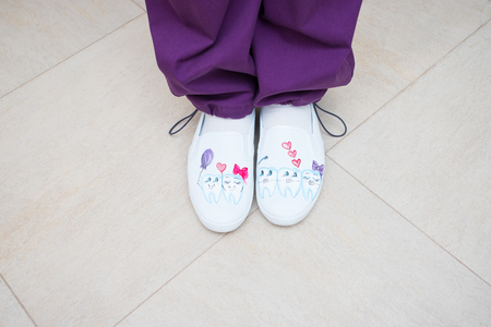 feet of the dentist in shoes with pictures, the subject of dentistry, top view. professional shoesの写真素材