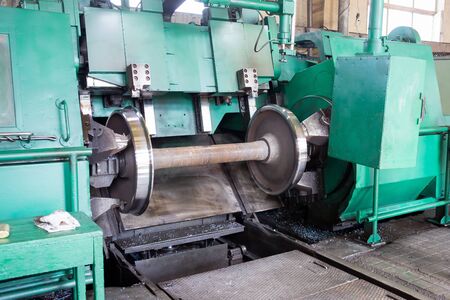 Railway wheelset in a lathe after repair. Repair shop of railway carsの写真素材