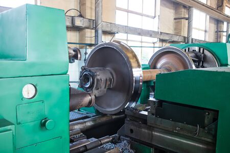 Railway wheelset in a lathe after repair. Repair shop of railway carsの写真素材