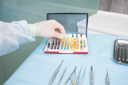 The dentists hand takes the endodontic obstructive dental equipment in the dentists officeの写真素材